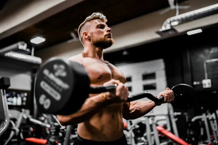 Lifter performing a barbell curl with an EZ bar